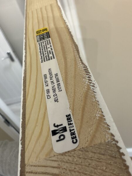 Close-up of the certification label on a fire door's hinge edge