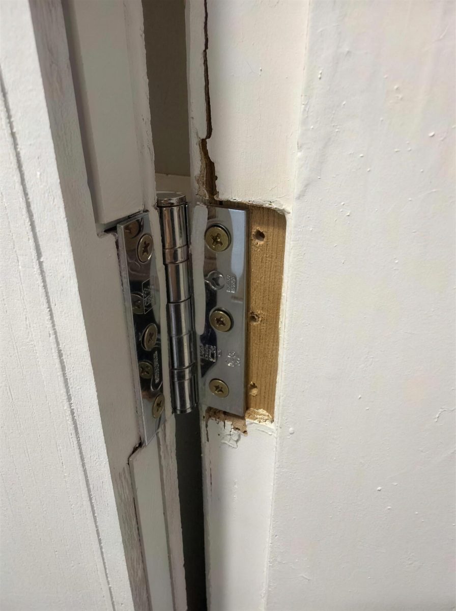 Damaged hinge recess where a fire door frame has split