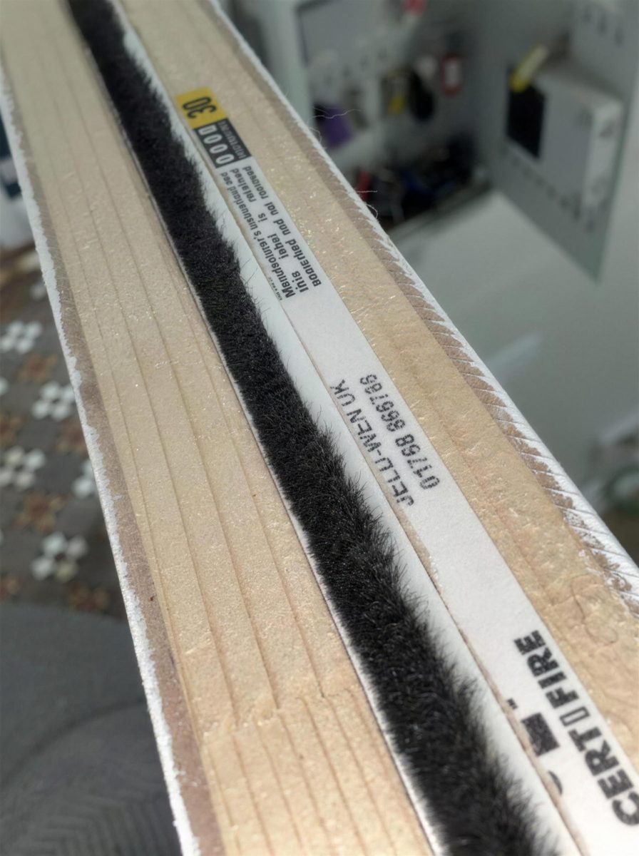 Smoke seal brush strip along the edge of a fire door